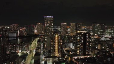 Aerial view of tall residential and office buildings in modern city at night. High quality 4k footage