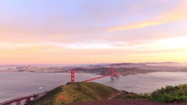 Sunset time lapse of traffic on Golden Gate Bridge and Marin Headlands with city in background. High quality 4k footage