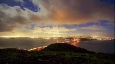Bulutlar geceleri Golden Gate Köprüsü ve San Francisco 'dan geçiyor. Yüksek kalite 4k görüntü