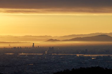 Şehir ve doğa üzerindeki sis, güneş doğarken turuncu parlaklığa neden olur. Yüksek kalite fotoğraf