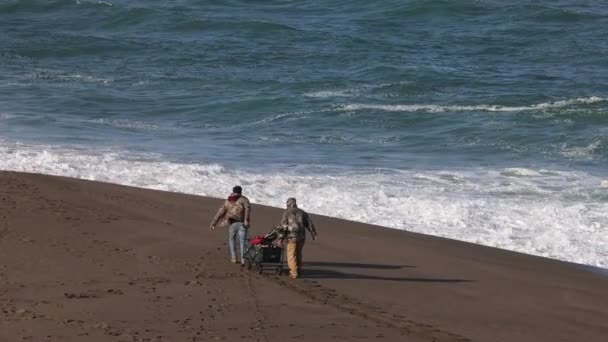 Fishermen Pull Wagon Fishing Gear Sandy Beach Breaking Waves High — Stock Video