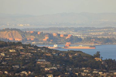 Depo tanklarının yakınına yanaşan kargo gemisiyle Green Hill 'deki evler. Yüksek kalite fotoğraf