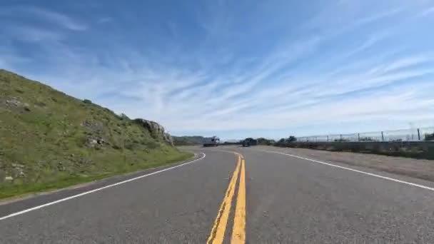 カリフォルニア海岸の崖の上の風の強いハイウェイ1号線沿いのサイクリストペダル 高品質4K映像 — ストック動画