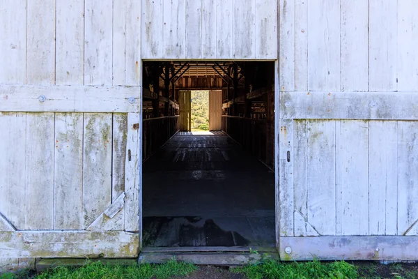 Point Reyes, California 'daki tarihi Pierce Point Çiftliği' nin içi karanlık ve parlak görünümlü açık ahır kapısı. Yüksek kalite fotoğraf