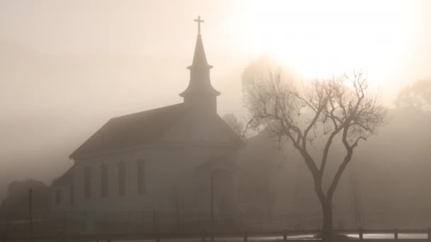 Carro Clássico Dirige Por Pequena Igreja Nevoeiro Pesado Com Sol — Vídeo de Stock