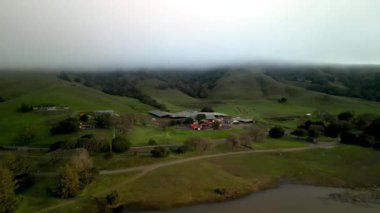 Alçak Sis Battaniyesi Şafak vakti Green California Hills 'teki Rustik Çiftlik Binaları' nın üzerinde. Yüksek kalite 4k görüntü