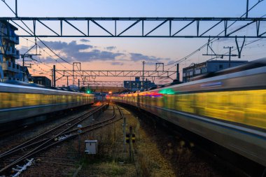 Günbatımında yerleşim bölgelerinde tren rayları bulanıklaşıyor. Yüksek kalite fotoğraf