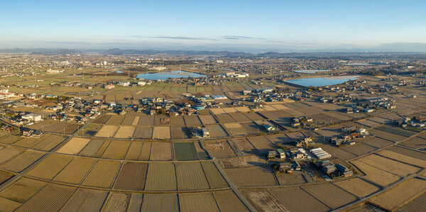 Aerial view of dry farms and fields by homes in rural farming town. High quality photo