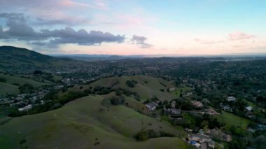 Gün batımında Marin County, California 'daki yeşil tepelerin etrafında ikamet eden banliyöler. Yüksek kalite 4k görüntü