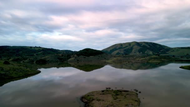 Політ Над Спокійною Водою Озері Зеленими Пагорбами Кольором Сходу Сонця — стокове відео