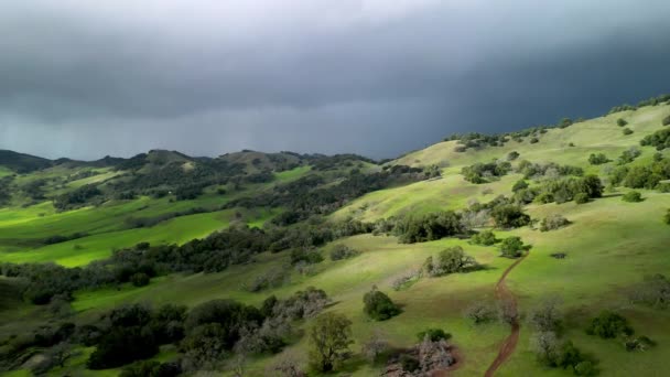 Letecký Pohled Turistické Stezky Zelené Kopcovité Krajině Blížícími Dešťovými Mraky — Stock video