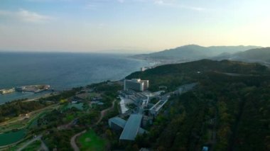 Awaji Adası 'nda gün batımında sahil oteli ve bahçeler etrafında hava rotasyonu. Yüksek kalite 4k görüntü