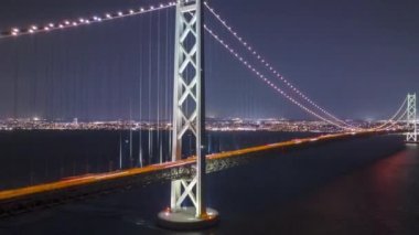 Arabalar gece Akashi Kaikyo asma köprüsünden Awaji Adası 'na gidiyor. Yüksek kalite 4k görüntü