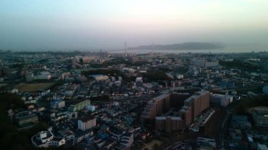 Alacakaranlıkta köprüsü ve adası olan küçük şehirlerin üzerinde uçuyorlar. Yüksek kalite 4k görüntü