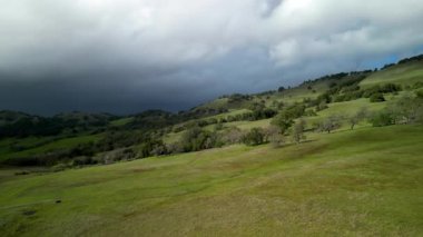Koyu yağmur bulutları Kaliforniya 'nın güzel yeşil tepelerinde hareket eder. Yüksek kalite 4k görüntü