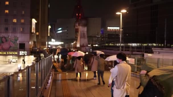 Люди Ходять Парасолями Пішохідному Мосту Станції Умеда Дощову Ніч Кадри — стокове відео