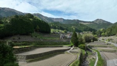 Güneşli bir günde küçük bir dağ köyündeki teraslı tarlaların üzerinden yükselin. Yüksek kalite 4k görüntü