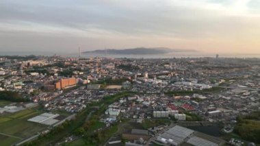 Gün batımında köprüden adaya uzanan geniş kıyı şehrinin havadan görüntüsü. Yüksek kalite 4k görüntü