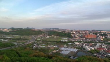 Hava trafiği otobandan sahil şehrine ve köprüden altın saat ışığında dönüyor. Yüksek kalite 4k görüntü