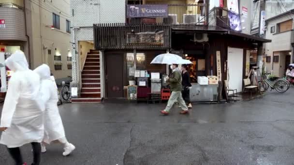 日本大阪 2023年4月29日 带着雨伞和雨伞的人们在日本街头行走 高质量的4K镜头 — 图库视频影像