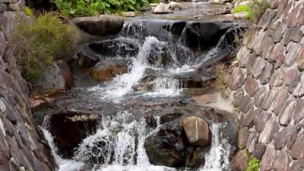 Agua Desciende Por Una Pequeña Cascada Arroyo Forrado Piedra Imágenes — Vídeo de stock