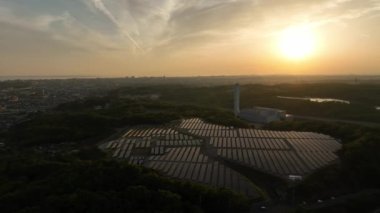Gün batımında temiz enerji üretim tesisinde güneş panelleri üzerinde uçmak. Yüksek kalite 4k görüntü