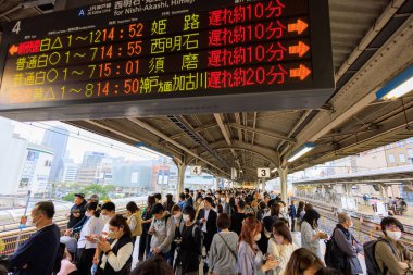 Kobe, Japonya - 6 Mayıs 2023: Yolcular, Altın Hafta Tatili sırasında JR Sannomiya İstasyonu 'nda tren gecikmeleri nedeniyle platformda imza altında bekliyorlar. Yüksek kalite fotoğraf