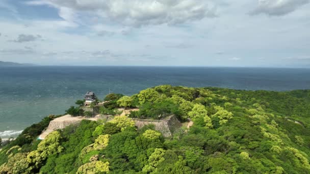 Zbliżamy Się Historycznego Japońskiego Zamku Wzgórzu Widokiem Błękitne Morze Wysokiej — Wideo stockowe