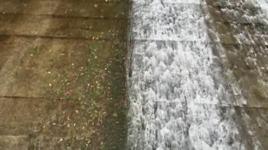 Barajdan dökülen suyun tepeden görünüşü küçük beton havuza dökülüyor. Yüksek kalite 4k görüntü
