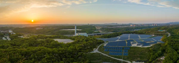 Güneş çiftliğindeki günbatımının panoramik hava manzarası ve tepe panelleri. Yüksek kalite fotoğraf