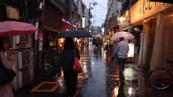 2023年4月29日 人々は夕暮れ時に梅雨の季節に日本の兆候と狭い通りを歩く 高品質4K映像 — ストック動画