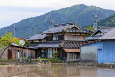 Geleneksel Japon ahşap evi, sel basmış pirinç tarlasıyla küçük bir kasabada. Yüksek kalite fotoğraf