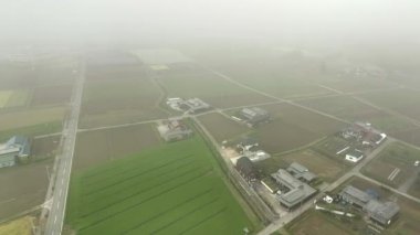 Japon kırsalındaki evler ve çiftlikler üzerinde alçak bulut ve sis. Yüksek kalite 4k görüntü