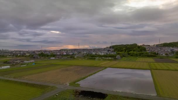 時間の経過 日没時に雲が畑や農場で小さな町を移動します 高品質4K映像 — ストック動画