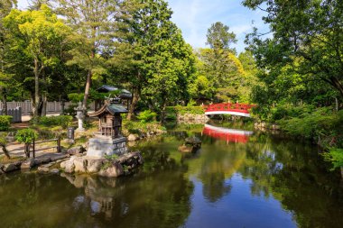 Kırmızı köprü tapınaktaki Japon bahçesindeki sakin gölete yansıyor. Yüksek kalite fotoğraf