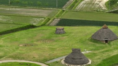 Jomon köyünün tarihi dinlenme yerindeki sazdan çatı kulübelerinin havadan görünüşü. Yüksek kalite 4k görüntü