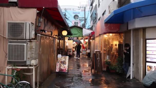 日本大阪 2023年4月29日 随着雨点落在有酒吧和餐馆的狭窄小巷上 人们开始吸烟 高质量的4K镜头 — 图库视频影像