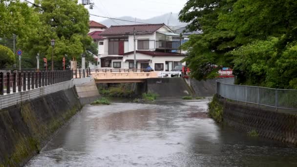 Woda Spływa Rzece Pod Mostem Rowerzystą Samochodem Deszczowe Dni Japonii — Wideo stockowe
