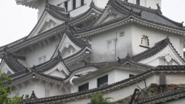 Gri bulutlu bir günde Himeji 'deki tarihi Japon şatosuna doğru eğil. Yüksek kalite 4k görüntü