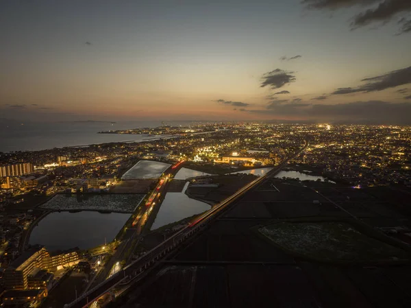 Yüksek hızlı trenden gelen bulanık ışıklar ve alacakaranlıkta şehre giden arabalar. Yüksek kalite fotoğraf