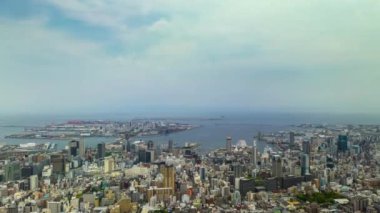 Zaman aşımı: Bulutlar güneşli bir günde Kobe City şehir merkezine ve liman bölgesine doğru hareket ediyor. Yüksek kalite 4k görüntü