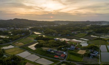 Geleneksel tarım köyündeki evler ve pirinç tarlaları üzerinde gün batımı gökyüzü. Yüksek kalite fotoğraf