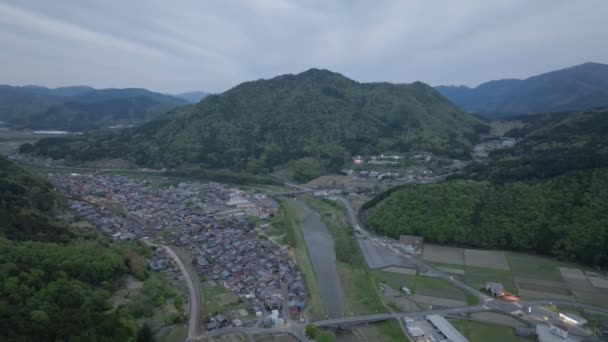 Volando Sobre Una Pequeña Ciudad Río Río Paisaje Montaña Atardecer — Vídeos de Stock