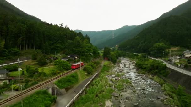 Treno Rosso Monoposto Rotaia Lungo Fiume Nel Verde Paesaggio Montano — Video Stock