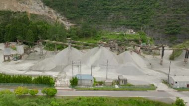 Açık maden ocağındaki malzeme yığınlarının ve taşıyıcı makinelerin üzerinde uçan kule. Yüksek kalite 4k görüntü