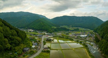 Dağ vadisindeki sel basmış pirinç tarlalarının köy ve nehir manzarası. Yüksek kalite fotoğraf