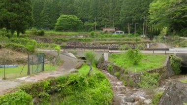 Eski taş duvarların ve nehrin üzerinden küçük tarlalara ve kırsal kulübelere uçuyorlar. Yüksek kalite 4k görüntü