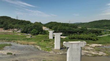Nehir üzerindeki tamamlanmamış köprü için beton destek sütunlarının üzerinden uçuyorlar. Yüksek kalite 4k görüntü