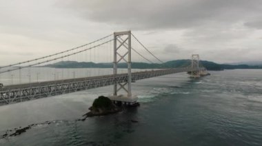 Tur otobüsü, dönen sular ve Naruto girdapları üzerinde köprüden geçer. Yüksek kalite 4k görüntü