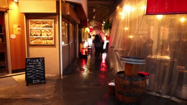 日本大阪 2023年4月29日 塑料薄片保护餐厅小巷内的食客免受夜间雨淋 高质量的4K镜头 — 图库视频影像